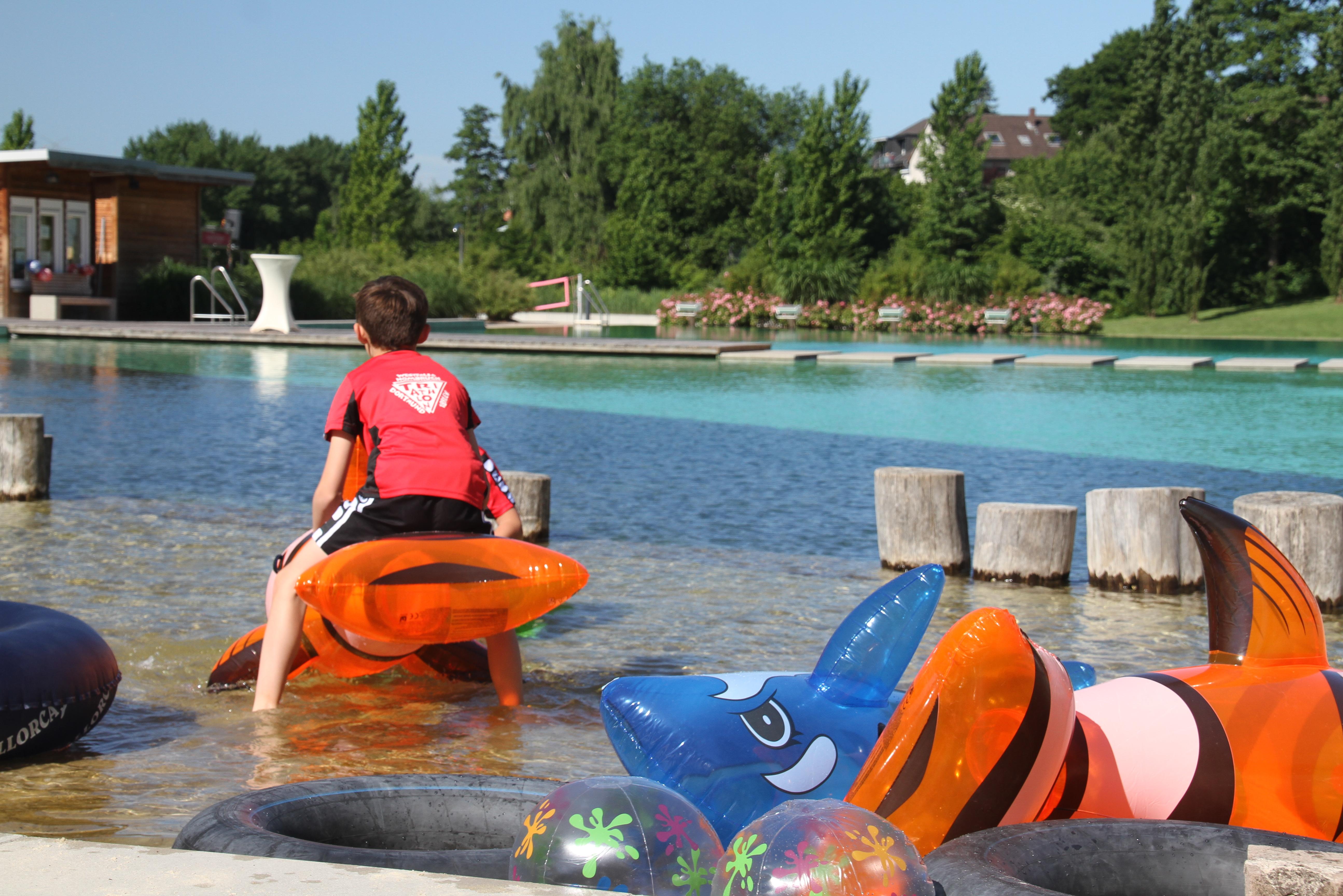 Spiel & Spaß mit Schwimmtieren Kinder spielen mit Schwimmtieren im flachen Wasser